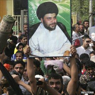 Supporters of Shia cleric Moqtada Sadr hold up his picture in Sadr City