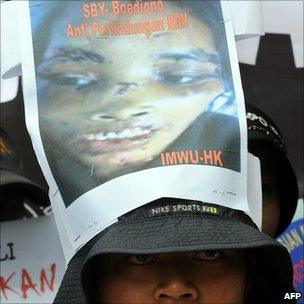 A member of Migrant Care Indonesia wears a picture of Sumiati Binti Salan Mustapa on her hat during a protest at the Saudi Arabian embassy in Jakarta
