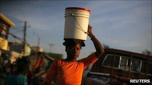 A girl carries a bucket of water in Port-au-Prince on 21 November