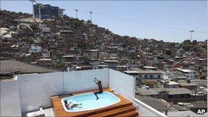 Local children play in a swimming pool after police finish their search of a house of an alleged drug dealer in Complexo do Alemao