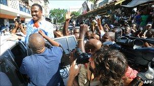 Jude Celestin is surrounded by supporters and the press (28 November 2010)