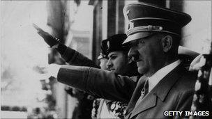 Adolf Hitler and Benito Mussolini give the fascist salute at a parade during 1943