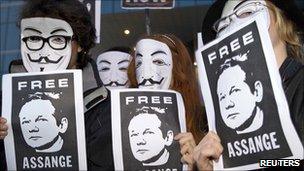Masked demonstrators hold posters calling for release of Wikileaks founder Julian Assange (Madrid, 11 December 2010)