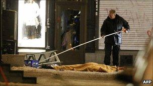 A police forensics officer examines the area around the man killed in Stockholm, 11 December