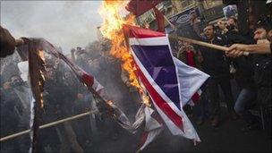 Iranian university students burn a British flag during a protest outside the British embassy in central Tehran December 12, 2010.