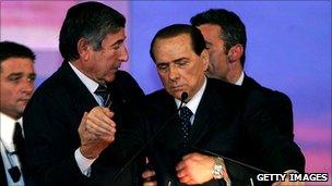 Silvio Berlusconi collapses while making a political speech in Montecatini, 26 November 2006. His bodyguards immediately stepped in to stop him falling over.