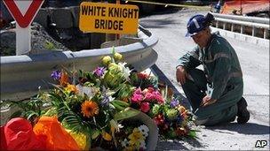 A miner lays down flowers at White Knight Bridge near the entrance to the Pike River mine where 29 miners died, in Greymouth