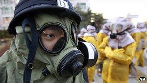 South Korean police and civilians wear gas masks during a civil defence drill
