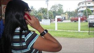 Journalist Malu taking a call at the entrance to her radio station