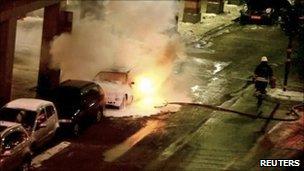 Video footage showing a firefighter attempting to put out the fire on a burning car in Stockholm (11 December 2010)