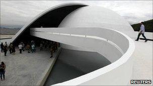 Visitors admire the white curves of the Oscar Niemeyer Foundation building in Niteroi