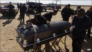 Relatives mourn a police officer killed in Ciudad Juarez on 4 December 2010