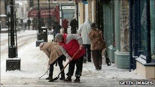 Shopkeepers try to clear snow