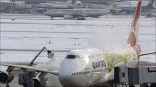 Workers defrost a plane at Heathrow Airport