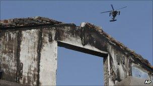 South Korean helicopter flies over house on Yeonpyeong island destroyed by North Korean shelling