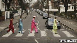 Actors play the part of the Beatles crossing a zebra crossing outside the Abbey Road studios