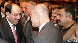 Prime Minister Nouri Maliki (L) is congratulated after forming the new government at the parliament in Baghdad