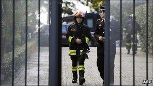 Italian firefighters and a policeman leave the Swiss embassy in Rome, 23 December