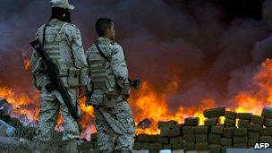 Two soldiers watch 134 tonnes of marijuana burning on October 20