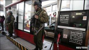 Police stand guard at a petrol station in La Paz, 26 Dec
