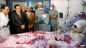 A handout picture released by the Tunisian Presidency on 28 December 2010 shows Tunisian President Zine al-Abidine Ben Ali (2nd L) looking at Mohamed Bouazizi(R), during his visit at the hospital