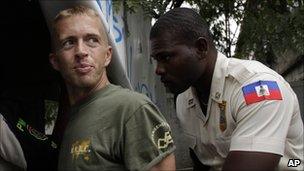 Paul Waggoner being escorted by a Haitian police officer