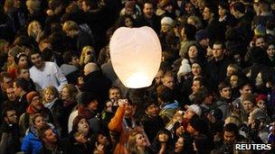 Revellers light a paper lantern during the New Year Hogmanay celebrations in Princes Street in Edinburgh