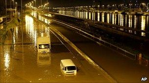 Abandoned vehicles sit in a flooded avenue after heavy rains in Sao Paulo