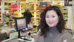 Ms Young A Hong stands in front of the checkout counters at the Korea Foods supermarket