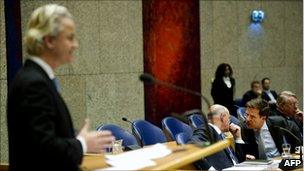 Geert Wilders (left) speaks during the Afghan debate as Prime Minister Mark Rutte (in silver tie) confers, 27 January