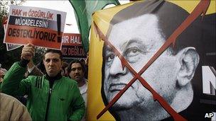 Protesters in Istanbul hold a poster showing the image of President Hosni Mubarak, 28 February 2011