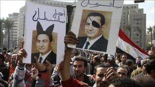 Protesters in Cairo, Egypt, hold defaced images of President Hosni Mubarak - 30 January 2011