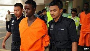 Malaysian police escort a suspected Somali pirate on 31 Jan 2011