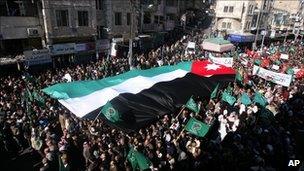 Protesters carry a national flag in Amman, Jordan (21 Jan 2011)