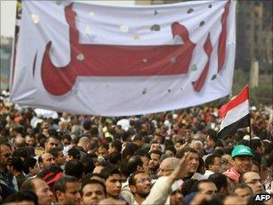 Protesters hold up a banner saying "Irhal" or "Depart"