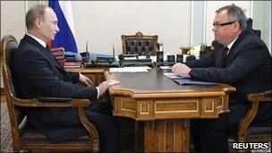 Russian Prime Minister Vladimir Putin listens to VTB head Andrei Kostin