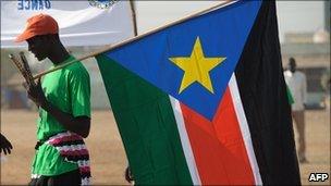 A man holds a SPLM flag in Juba - 30 January 2011