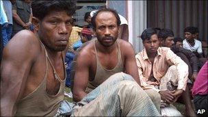 Rohingya men wait for medical treatment after being rescued, at a port in Aceh province, Indonesia