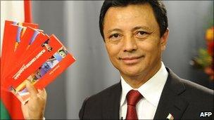 Former Madagascar President Marc Ravalomanana, ousted in a 2009 coup, shows plane tickets during a press conference on 17 February 2011 in Sandton, north Johannesburg