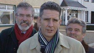 The BBC's Mark Simpson and Sinn Fein President Gerry Adams behind him (17 Feb 2011)