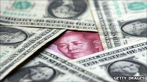 Face of Mao Zedong peaks out from a yuan note concealed in amongst dollar bills