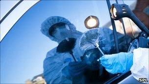 Forensics officer dusting for fingerprints