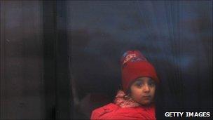 A girl who recently fled Libya sits on a bus with other displaced persons on the Tunisian side of the border on 23 February 2011 in Jdir, Tunisia