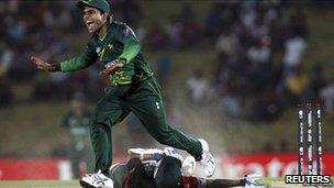 Pakistan's Umar Akmal (L) celebrates after running out Kenya's Seren Waters during their ICC Cricket World Cup group A match in Hambantota, south of Colombo, 23 February 2011