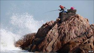 File image of a fisherman on a rocky outcrop in Hong Kong on 31 October 2010