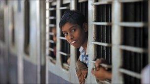 Boy looking out of a train in Kolkata train station