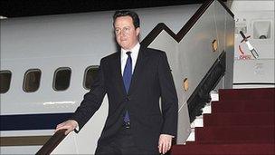 David Cameron getting off a plane during his four-leg Middle East trip