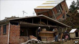 People recover furniture from a ruined home after a landslide in La Paz, Bolivia
