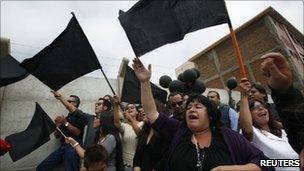 People in the Chilean town of Constitucion wave black flags in protest at government reconstruction efforts after the earthquake and tsunami of 27 February 2010
