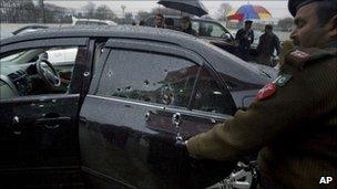Police inspect the bullet-riddled car in Islamabad on 2 March 2011